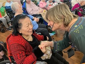 A Bridgeway Senior Healthcare activities director greets a resident during a holiday event.